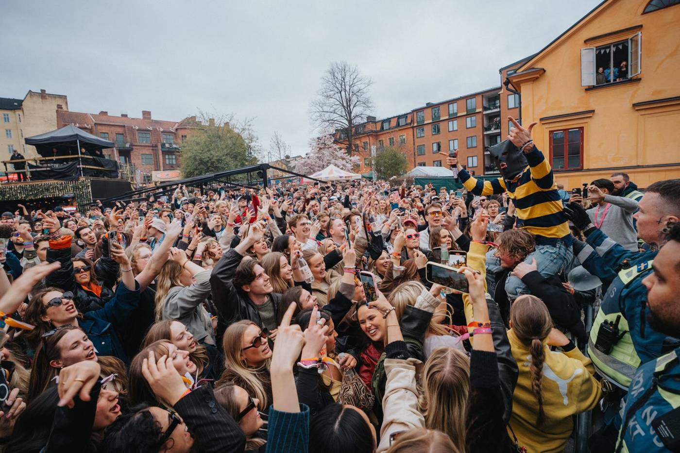 LOAM, masked, held up above a festival crowd